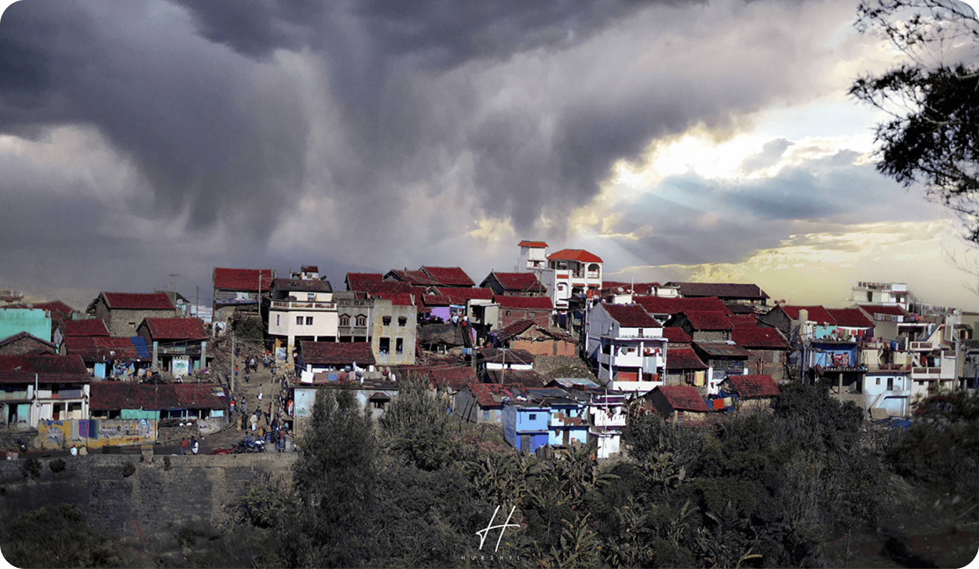 A hillside town under a passing storm